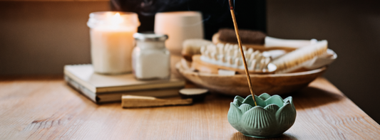 A candle and incense stick and skincare promoting self-care daily routines.