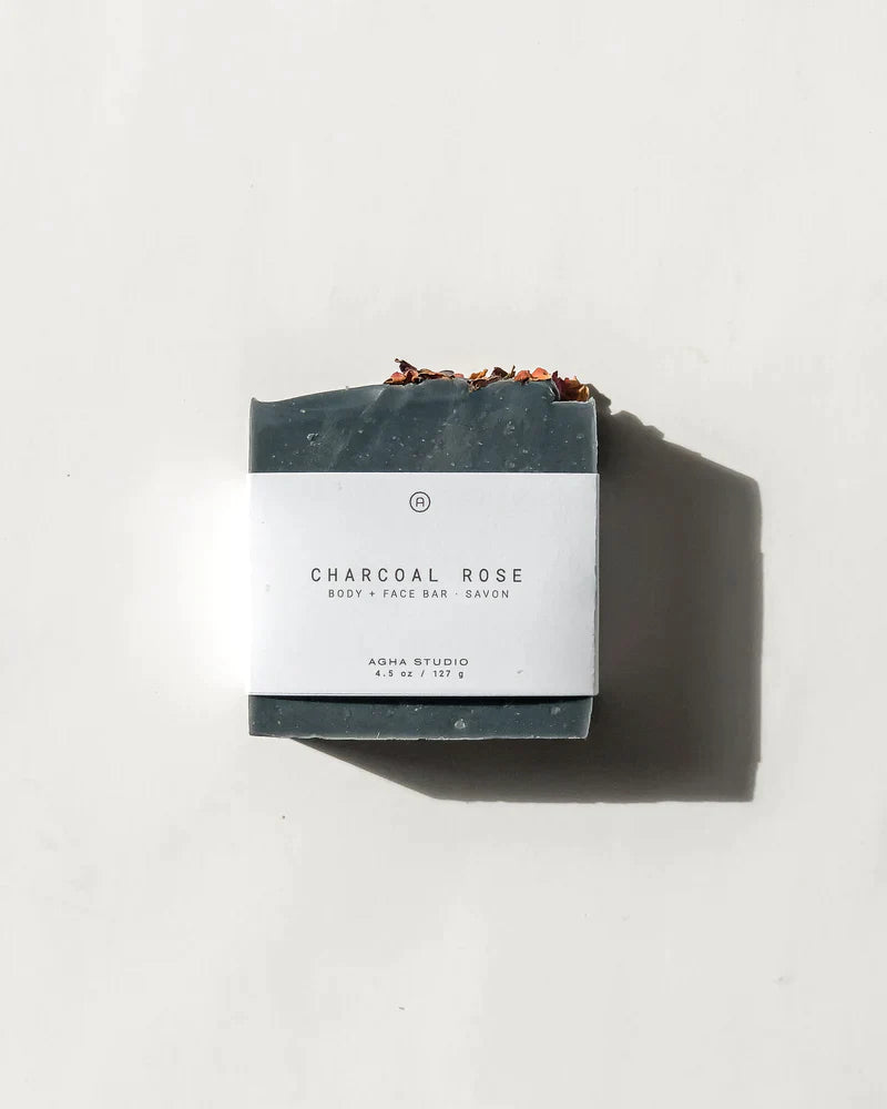 Natural and handmade charcoal bar soap for face and body topped with dried rose petals by Agha Studio.