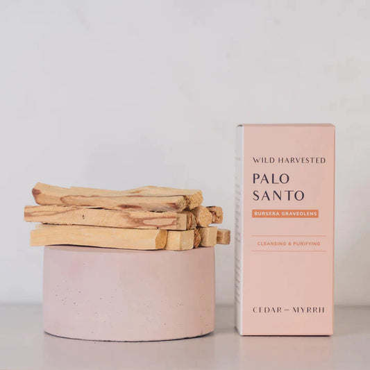 A bunch of palo santo sticks by Cedar and Myrrh, sitting on top of each other with its box next to it.