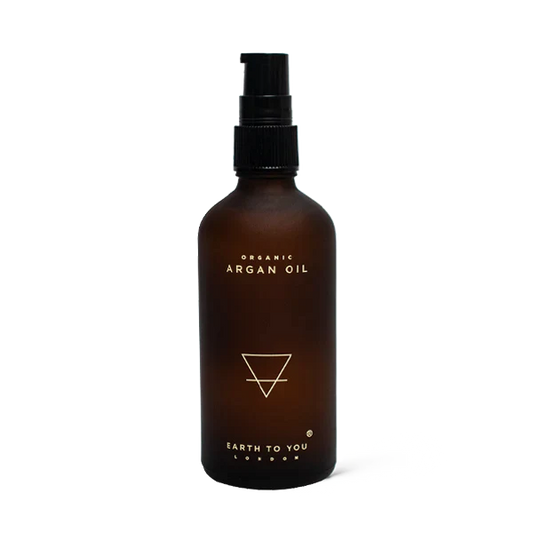 Bottle of a cold-pressed Argan hair oil by Earth To You to add shine and moisture to repair dry hair.