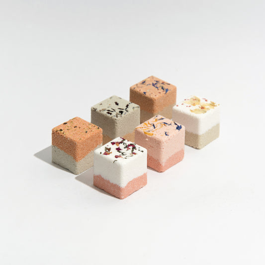 Cubes of bath fizzies naturally handmade by Even Keel, topped with dried flowers and colored with clay.