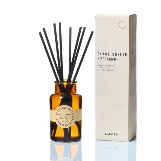 A reed diffuser in a brown glass apothecary bottle with black sticks made by Maegen to add aroma and fragrance to a room.